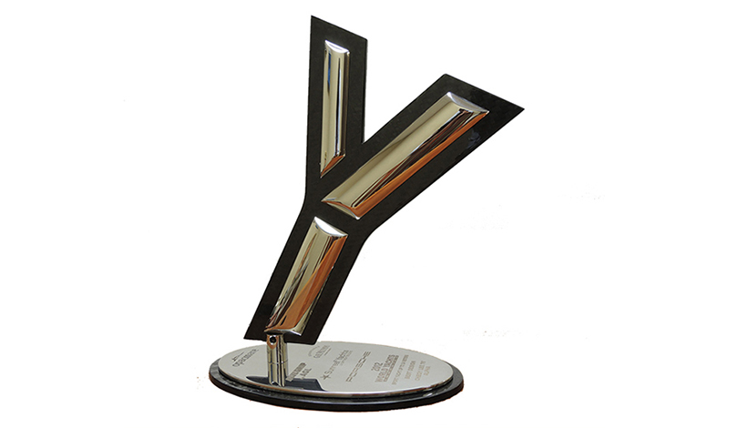 a yachting trophy in the shape of a gold y on a white background