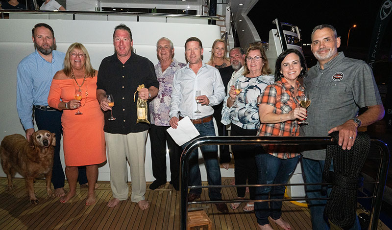 a group of people in front of a yacht