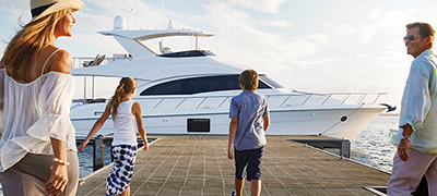 family walking down dock towards a yacht