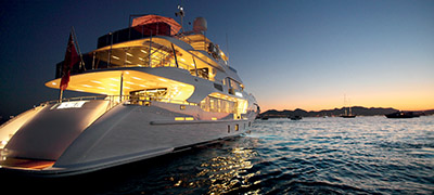 large yacht with light on at sunset