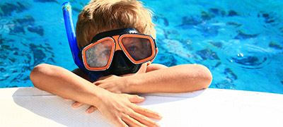 little kids with large goggles and snorkel on in the water