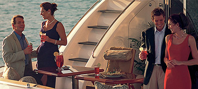 two couples with cocktails and appetizers on the aft deck of a yacht