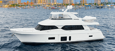 A white Ocean Alexander yacht sails in calm waters with a cityscape in the background, featuring skyscrapers and docked boats.