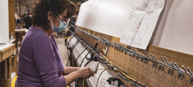 Woman with mask working on Cruisers Yachts model