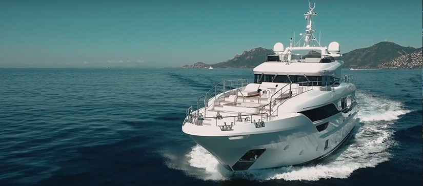 large white Benetti yacht running on the water