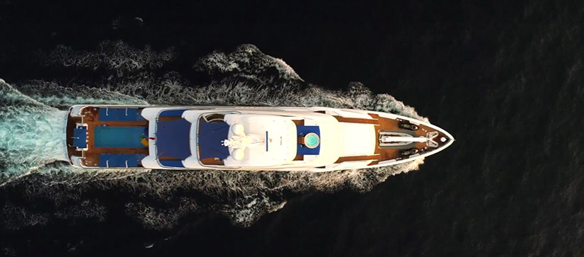 large white Benetti yacht running on the water