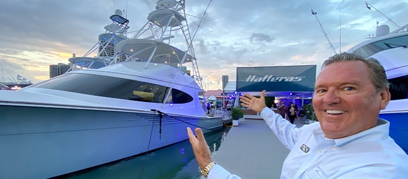 A MarineMax salesman pointing to a Hatteras yacht