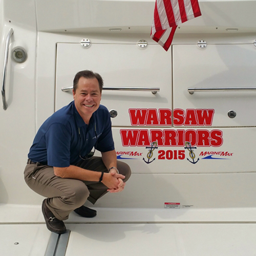 a man crouches in front of a boat