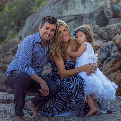 a couple stand on rocks with a young girl