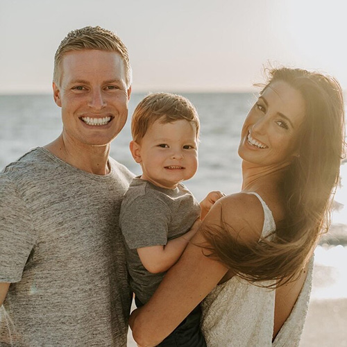 marinemax yachts team member kyle rice with wife ali and son henry together on a sunny beach
