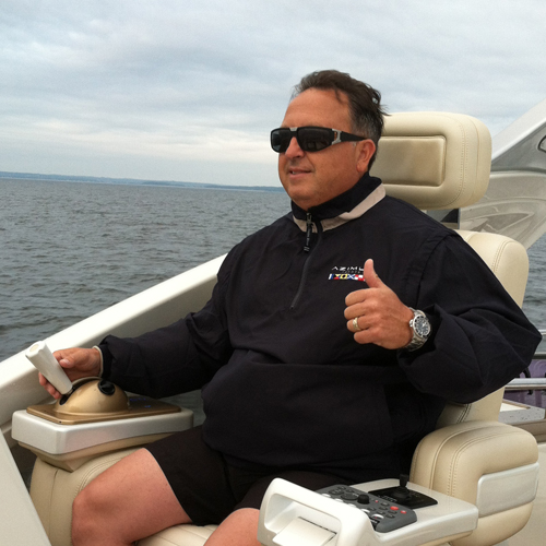 a man sits at the helm of a boat and gives s up