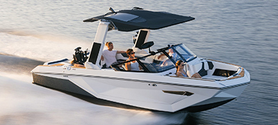 white wakeboard boat speeding across smooth water