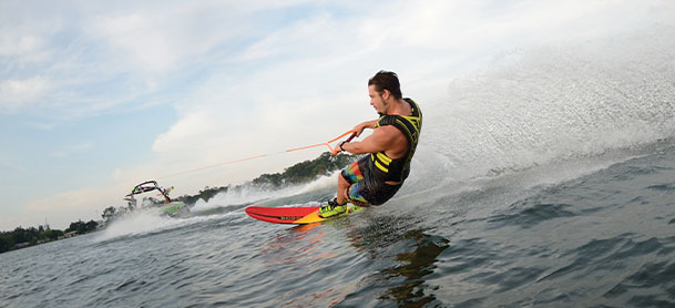 Man wakeboarding with boat in distance