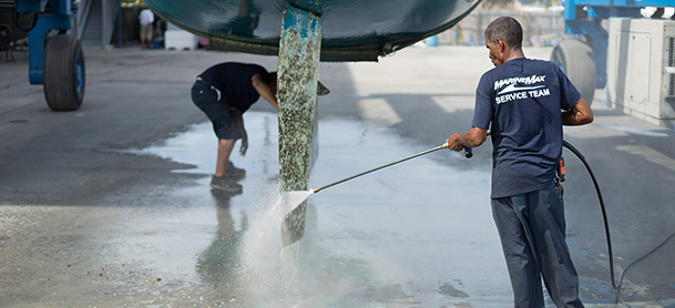 A MarineMax Technician cleans a boat's propeller